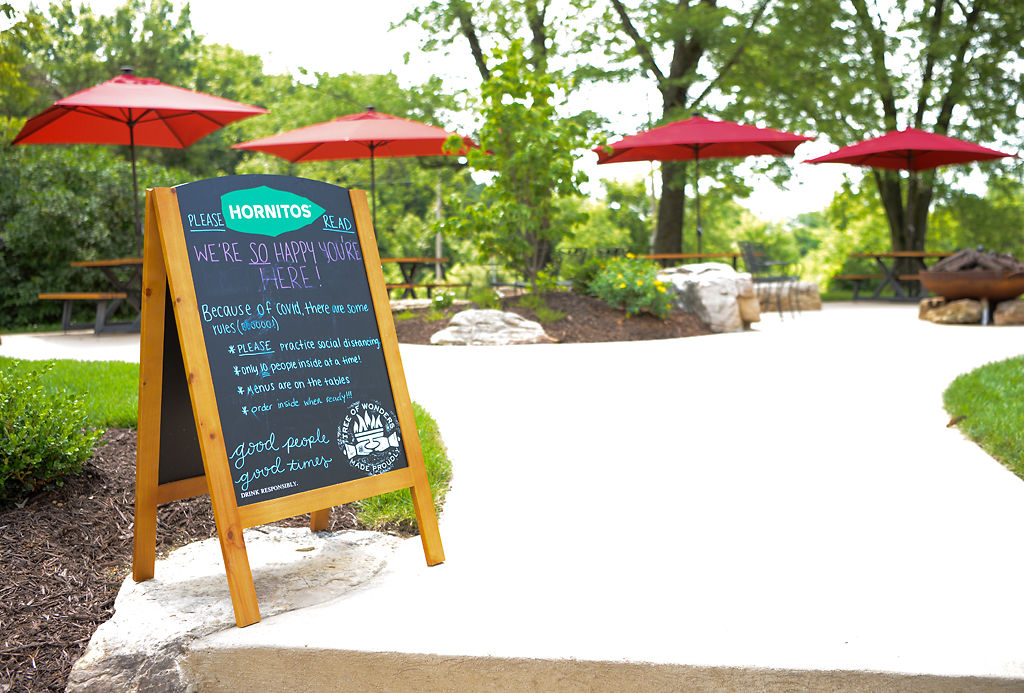 A sign at an outdoor seating area of Pierpont Café and Bar reminds customers to practice social distancing